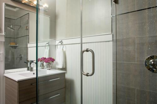 a bathroom with a shower with a sink and a glass shower door at L'Auberge Provencale Inn & Restaurant in Boyce