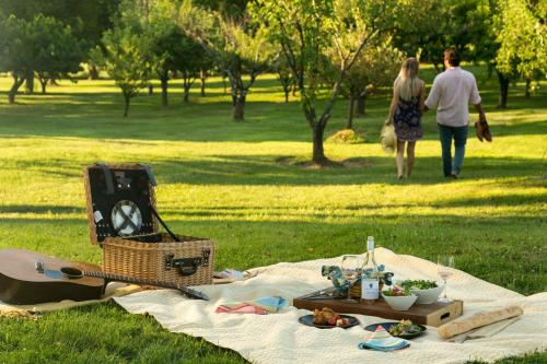 a picnic in the park with a man and woman walking at L'Auberge Provencale Inn & Restaurant in Boyce