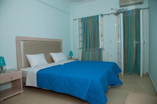 米爾托斯的住宿－米爾提尼公寓，蓝色卧室配有一张带蓝色床单的大床