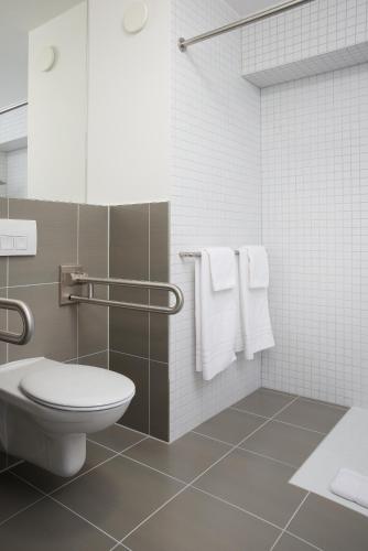 a bathroom with a toilet and white towels at MARA Hotel in Ilmenau