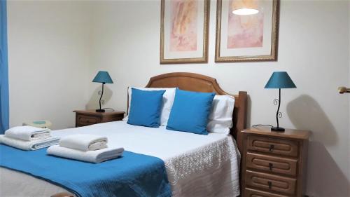 a bedroom with a bed with blue pillows at Casa da Avó Irene in Funchal