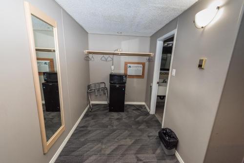 a hallway with a room with a door and a mirror at Olympia Lodge in Calgary