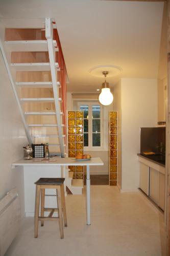 une cuisine avec une table et un escalier en colimaçon dans l'établissement La Maison bleue, à Rennes