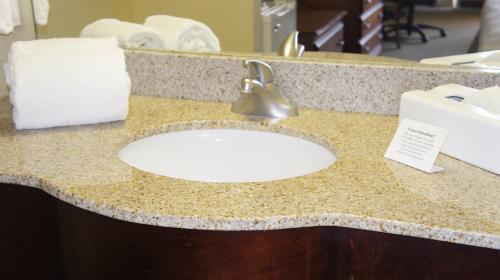 a bathroom counter with a white sink and towels at Village Inn Destin in Destin
