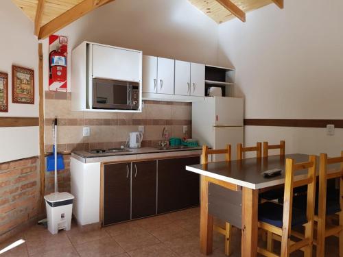 una pequeña cocina con mesa y encimera en Cabañas De La Comarca en El Bolsón