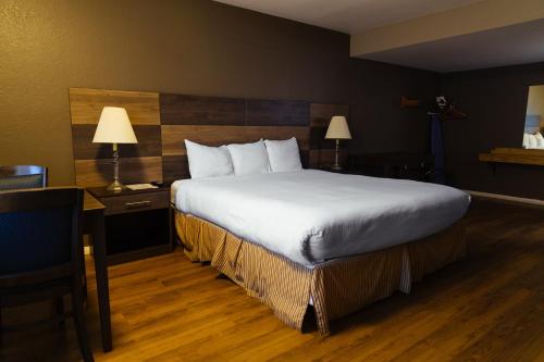 a hotel room with a large bed and two lamps at Cozy Inn in Costa Mesa