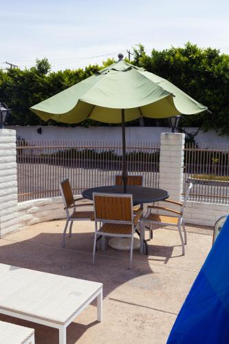 a table and chairs with an umbrella on a patio at Cozy Inn in Costa Mesa