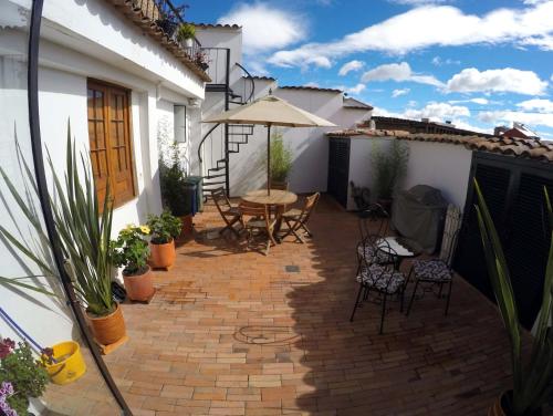 a patio with a table and chairs and an umbrella at Arche Noah Boutique Hostel in Bogotá