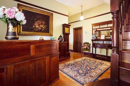 a living room with a vase of flowers on the wall at Kurrara Historic Guest House in Katoomba