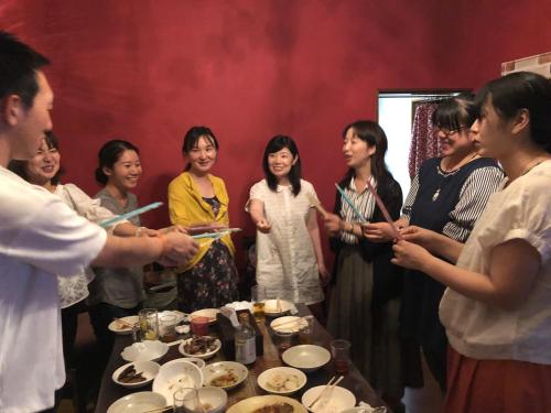 a group of people standing around a table with food at HappyCloset&WasamonHostel in Kumamoto
