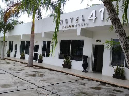 a building with palm trees in front of it at Hotel 41 Valladolid in Valladolid