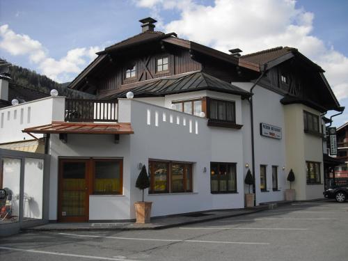 a white building with a black roof at Pizzeria Restaurant Wieser in Rasùn di Sotto
