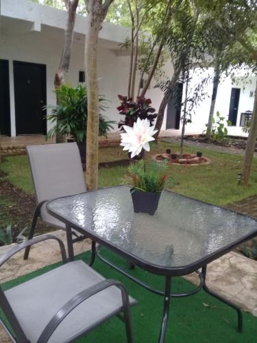 a patio table and chairs with a white flower on it at Hotel 41 Valladolid in Valladolid