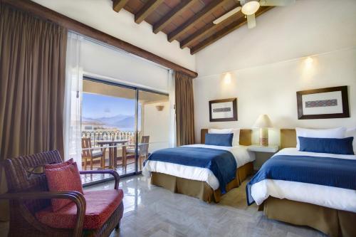 a hotel room with two beds and a balcony at Velas Vallarta Suite Resort All-Inclusive in Puerto Vallarta