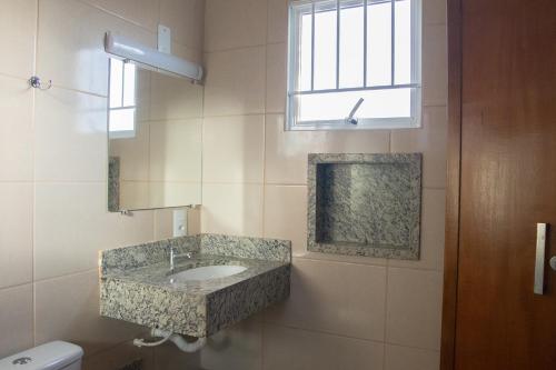 a bathroom with a sink and a window at Hotel Pousada João 3.16 in Barretos