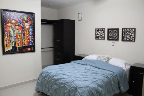 ein Schlafzimmer mit einem Bett und einem Wandgemälde in der Unterkunft Departamento zona dorada in Mazatlán