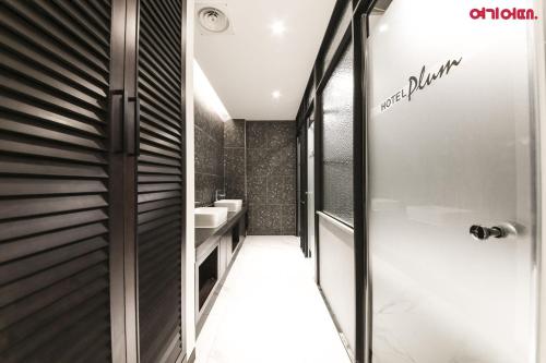 a bathroom with a shower and a sink at Plum Hotel in Siheung