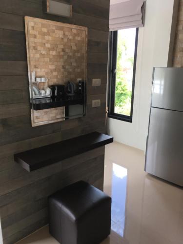a kitchen with a black stool and a refrigerator at Baan Fran Sim Da in Bang Tao Beach