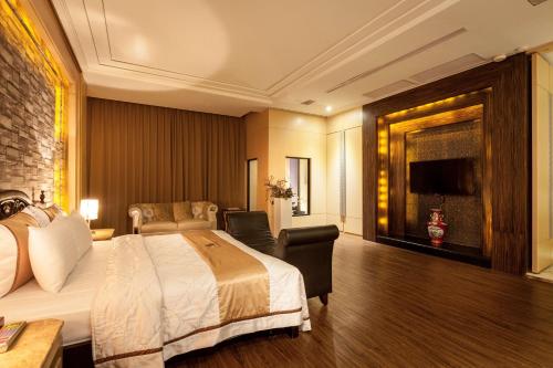 a hotel room with a bed and a television at Ouwei Motel in Tainan
