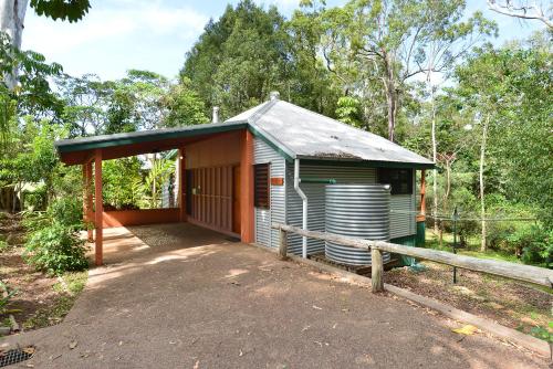 a small wooden house with a wooden fence at Bushland Cottages and Lodge in Yungaburra
