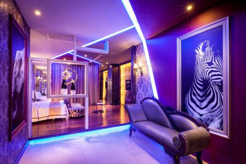 a purple room with a couch and a bed at Ouwei Motel in Tainan