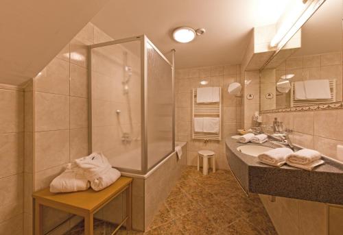 a bathroom with a shower and a sink and a tub at Hotel Truyenhof in Ried im Oberinntal