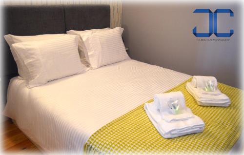 a bed with two towels and two plates on it at #Four Apartment by JC in Porto