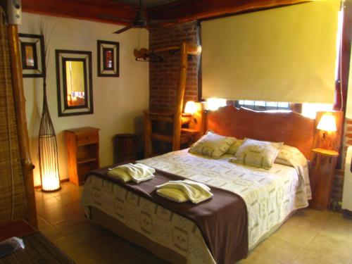 un dormitorio con cama con dos toallas en Loma Escondida Apart Cabañas & Spa en Villa Gesell