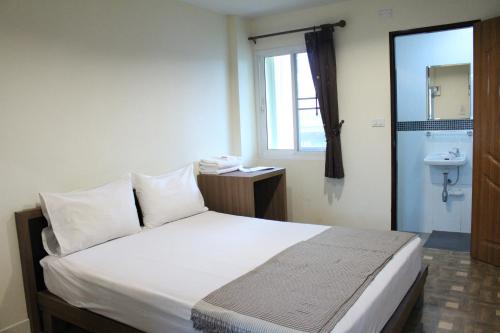 a bedroom with a bed with a sink and a window at Samsen Sam Place in Bangkok