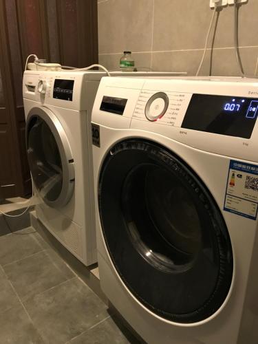 a white washing machine sitting in a room at Chongqing Ouranjian Lake View Guesthouse in Chongqing