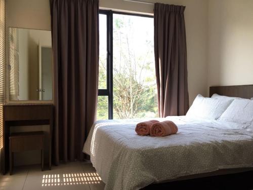 - une chambre avec un lit et 2 serviettes dans l'établissement Cozy Swiss Garden Beach Resort Residence, à Kampung Sungai Karang