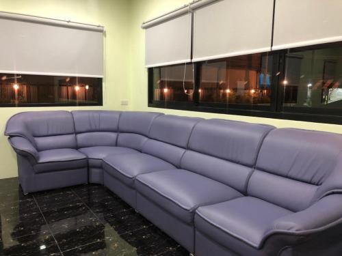a large purple couch in a room with windows at Thyme Xeriscape Hostel in Kanchanaburi