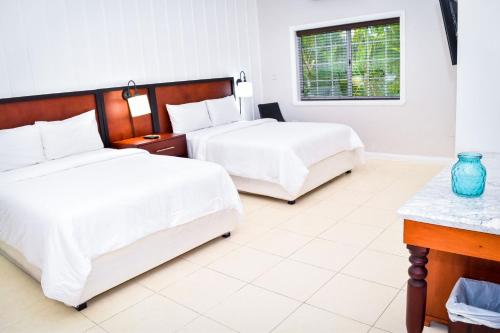 a bedroom with two beds and a window at JamGolia Place in Mandeville