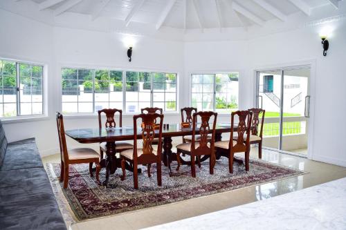 a dining room with a table and chairs on a rug at JamGolia Place in Mandeville