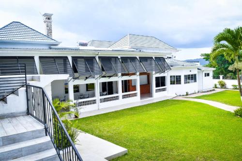 an exterior view of a white house with a yard at JamGolia Place in Mandeville
