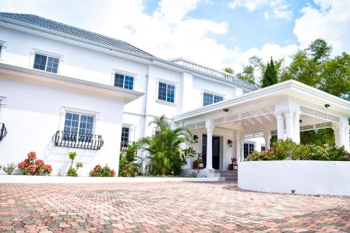 a white house with a brick driveway at JamGolia Place in Mandeville