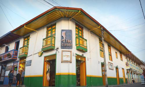 a white building with colorful windows on a street at The Corner House Hostel in Salento