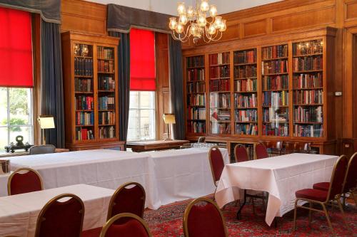 a room with a table and chairs and bookshelves at Ten Hill Place in Edinburgh