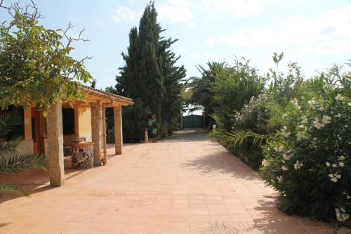 a brick walkway leading to a house with trees at Finca Verde in Llucmajor