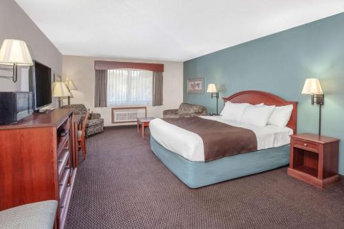 a hotel room with a bed and a television at AmericInn by Wyndham St. Peter in Saint Peter