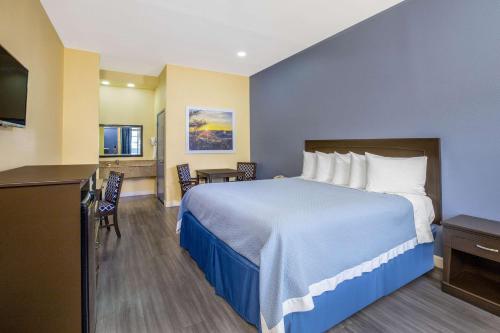 a hotel room with a large bed and a kitchen at Days Inn by Wyndham Banning Casino/Outlet Mall in Banning