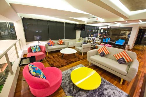 einen Blick über das Wohnzimmer mit Sofas und Stühlen in der Unterkunft Riverside Boutique Hotel in Kuantan