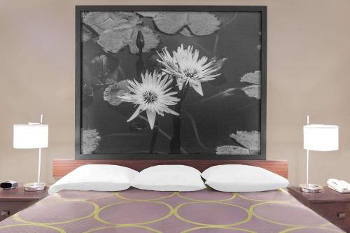 a black and white picture of flowers above a bed at Super 8 by Wyndham Bay St. Louis in Bay Saint Louis