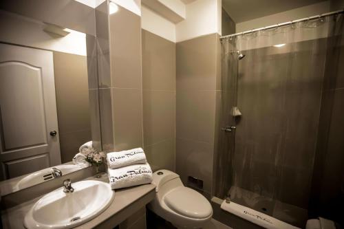 y baño con aseo, lavabo y ducha. en Hotel Gran Palma Talara, en Talara