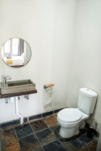 a bathroom with a white toilet and a mirror at Blue Rain Guest House in Bloemfontein