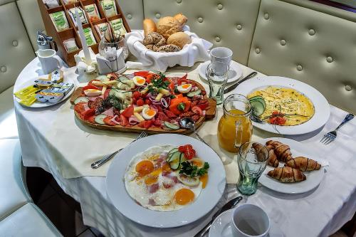 GyőrújbarátにあるAranypatkó Panzióの朝食の食べ物が載ったテーブル