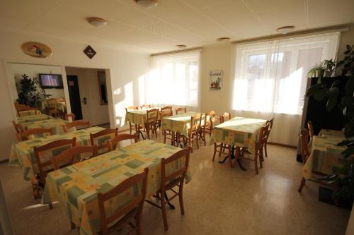 un comedor con mesas, sillas y ventanas en Hotel Abaca en Vevey