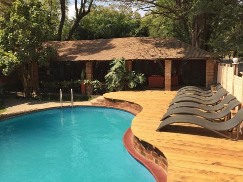 a swimming pool with chairs and a gazebo at Outpost Lodge in Arusha