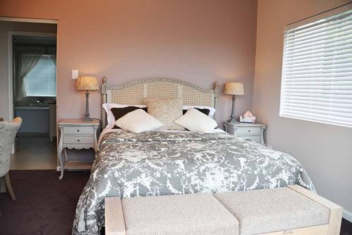 a bedroom with a bed and two tables and two lamps at 3 Oaklands on the Knoll in Knysna