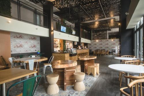 a restaurant with tables and chairs and a bar at Cuna Hotel in El Nido